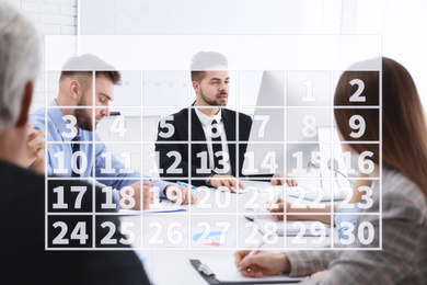 Image of Calendar and people having business meeting in office