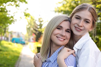 Photo of Happy mother with her daughter spending time together in park on sunny day