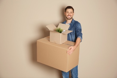 Photo of Man with moving boxes on color background