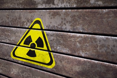 Image of Radioactive sign on metal surface, space for text. Hazard symbol