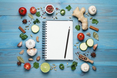 Photo of Open recipe book and different ingredients on light blue wooden table, flat lay. Space for text