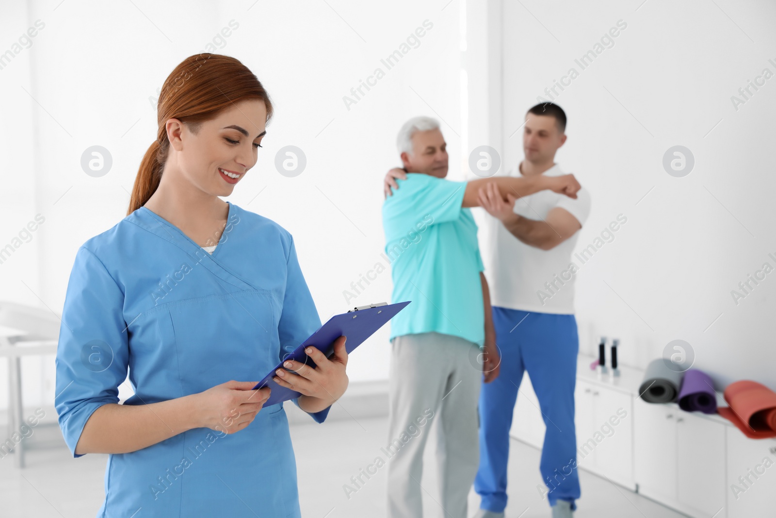 Photo of Portrait of professional physiotherapist with clipboard in rehabilitation center. Space for text