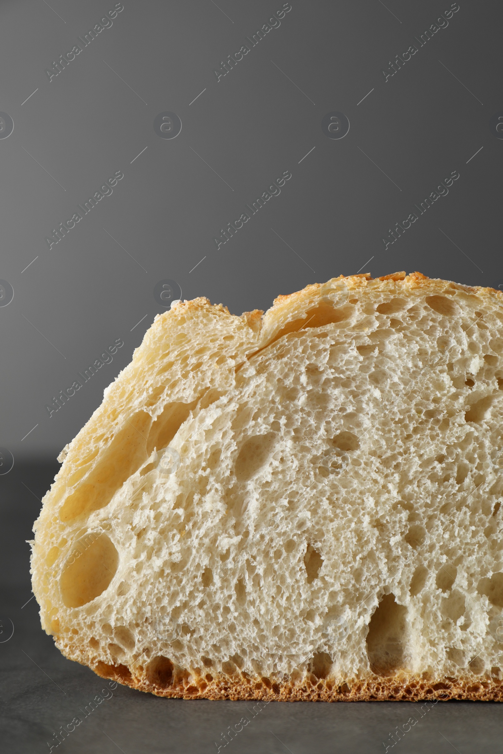 Photo of Freshly baked cut sourdough on grey table, closeup