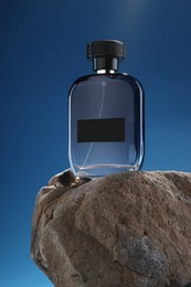 Stylish presentation of luxury men`s perfume on stone against light blue background
