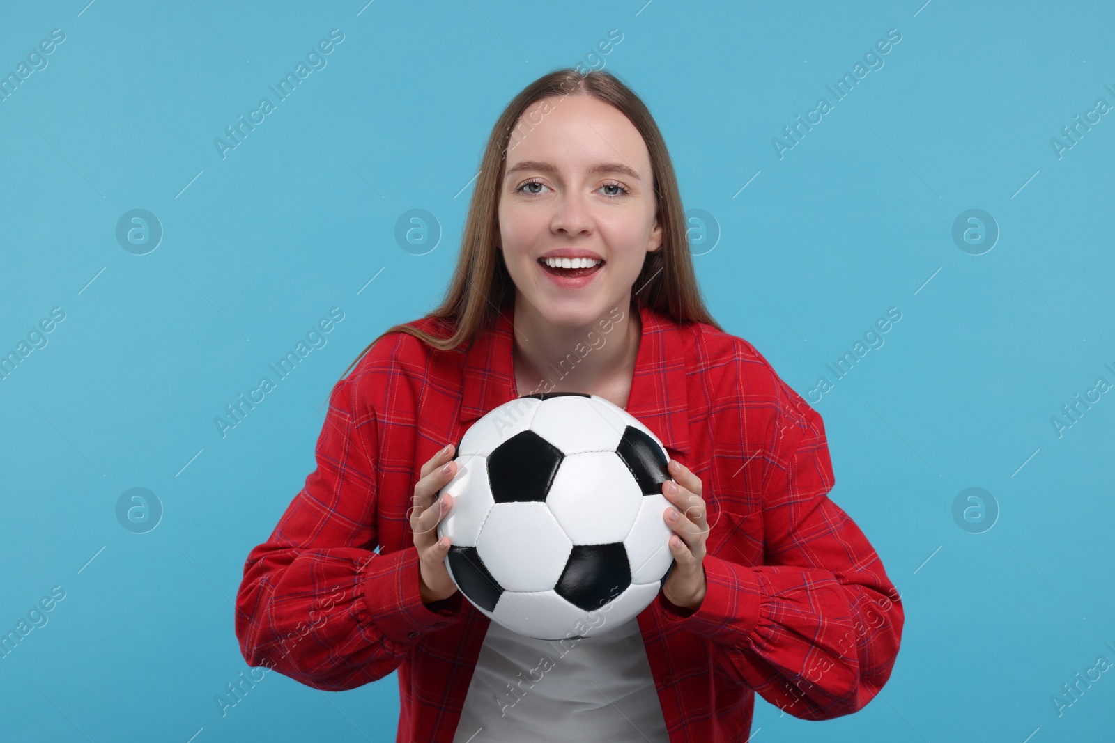 Photo of Emotional sports fan with ball on light blue background