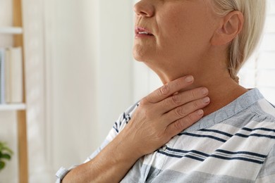 Photo of Mature woman doing thyroid self examination at home, closeup. Space for text