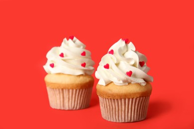 Photo of Tasty cupcakes for Valentine's Day on red background