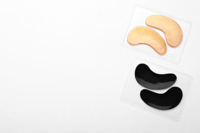 Packages with under eye patches on white background, top view. Cosmetic product