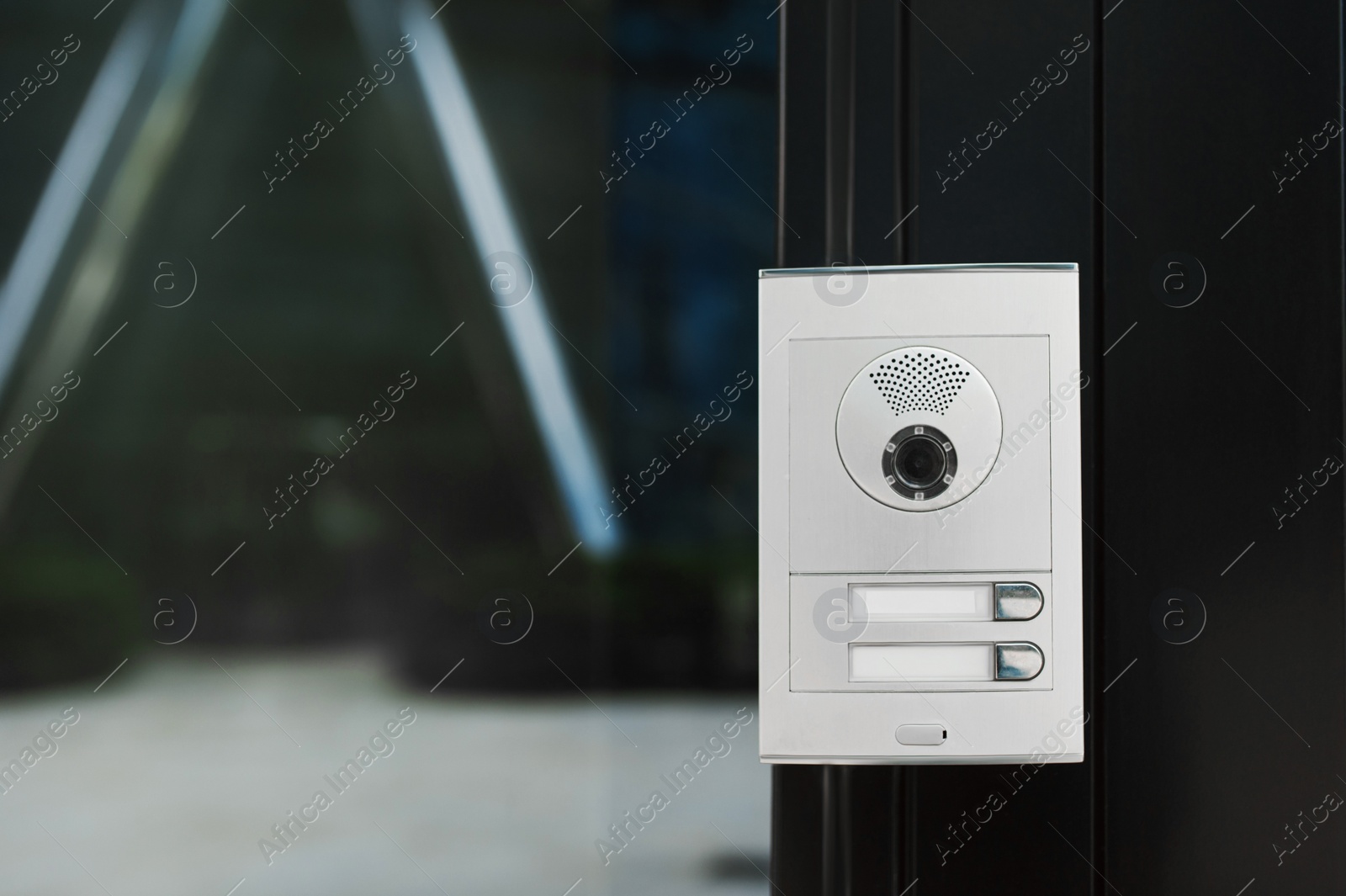 Photo of Modern intercom with camera hanging on door outdoors