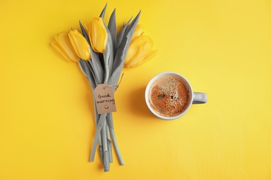 Color of the year 2021. Aromatic coffee, beautiful tulips and GOOD MORNING wish on yellow background, flat lay