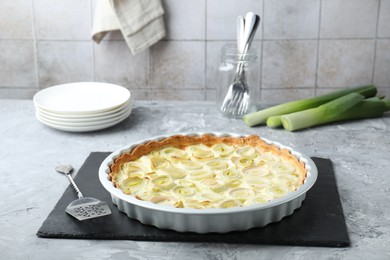 Photo of Freshly baked leek pie served on grey textured table