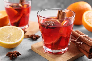 Photo of Aromatic punch drink and ingredients on white table, closeup