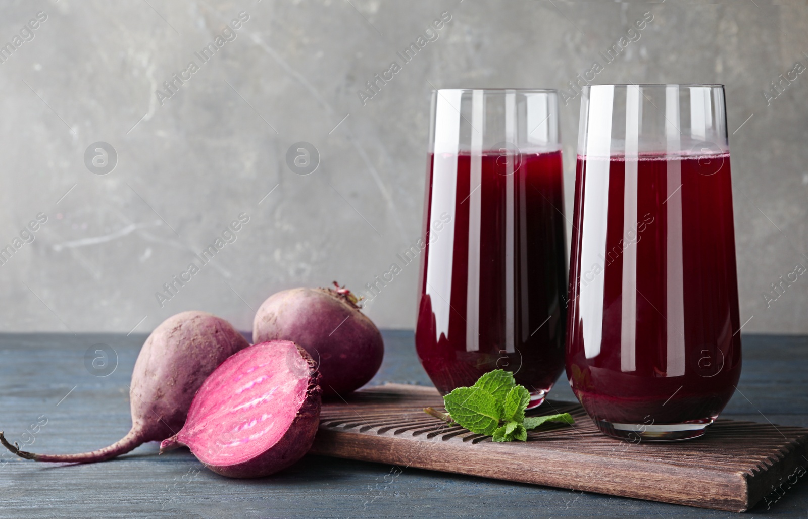 Photo of Composition with beet juice on table against grey background