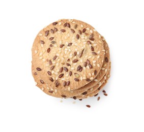 Photo of Stack of round cereal crackers with flax, sunflower and sesame seeds isolated on white, top view