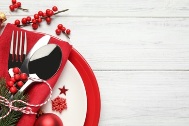 Beautiful Christmas table setting and festive decor on white wooden background, flat lay. Space for text