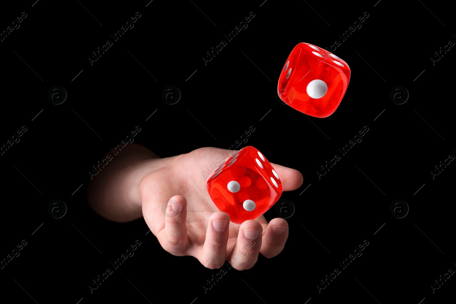 Image of Man throwing red dice on black background, closeup