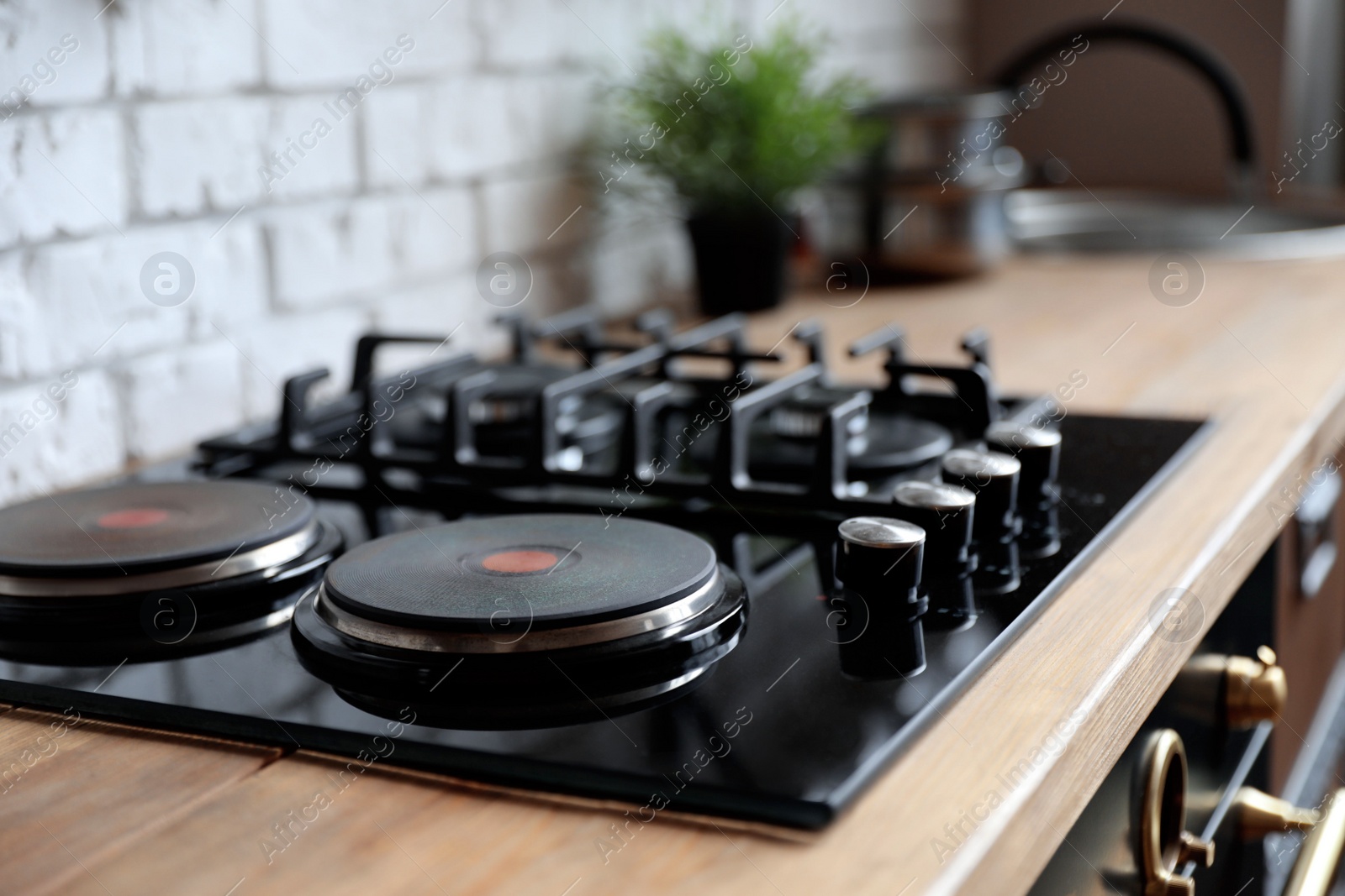 Photo of New modern stove with gas and electric burners in kitchen