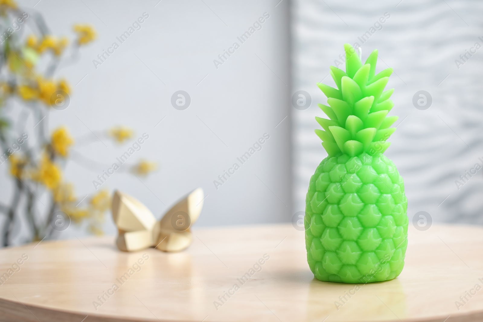 Photo of Pineapple shaped candle on table in room