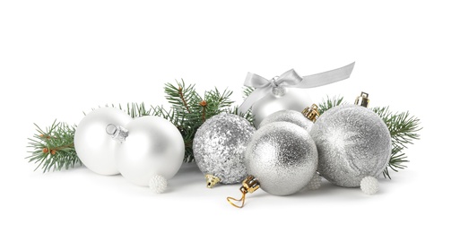 Beautiful Christmas balls and fir branches on white background