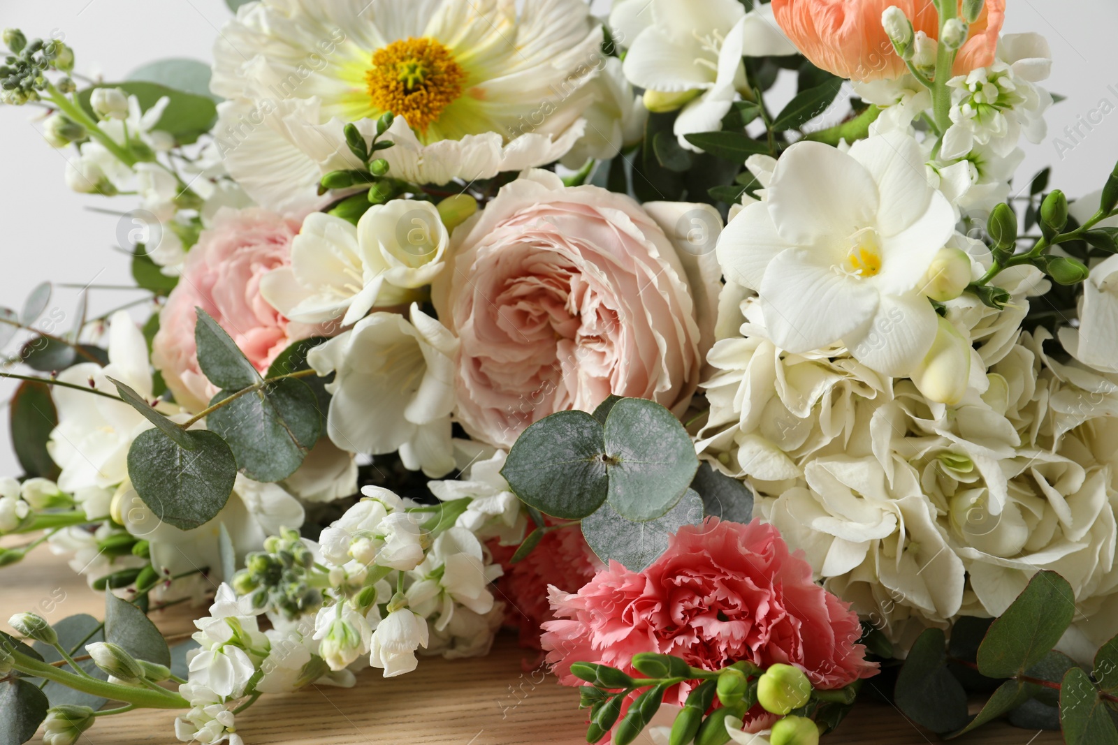 Photo of Bouquet of beautiful flowers on wooden table, closeup