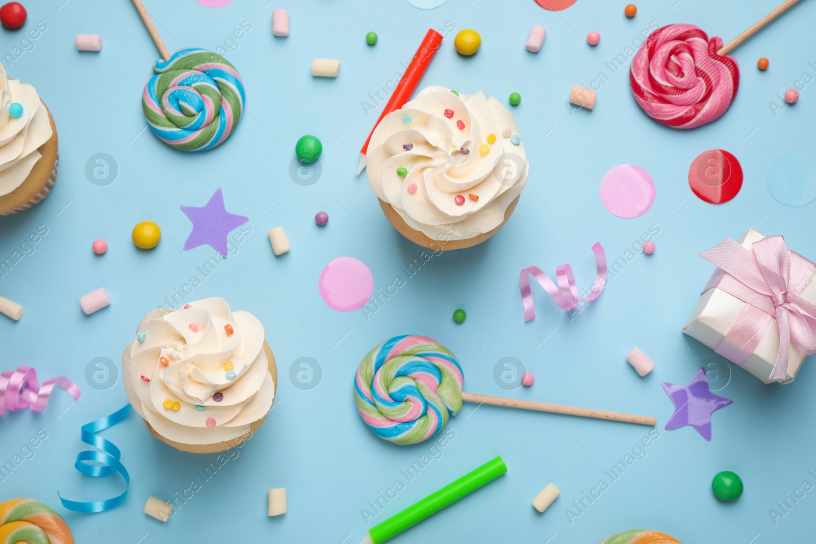 Photo of Flat lay composition with cupcakes on light blue background. Birthday party