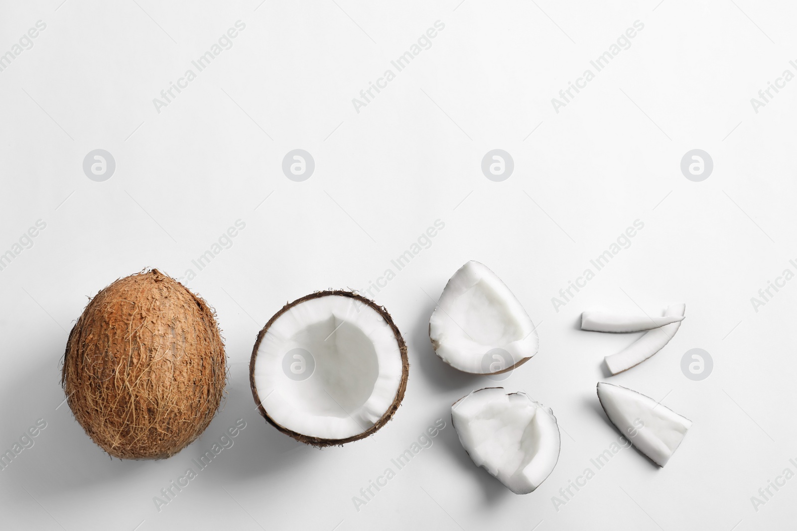 Photo of Pieces of coconut on white background, flat lay