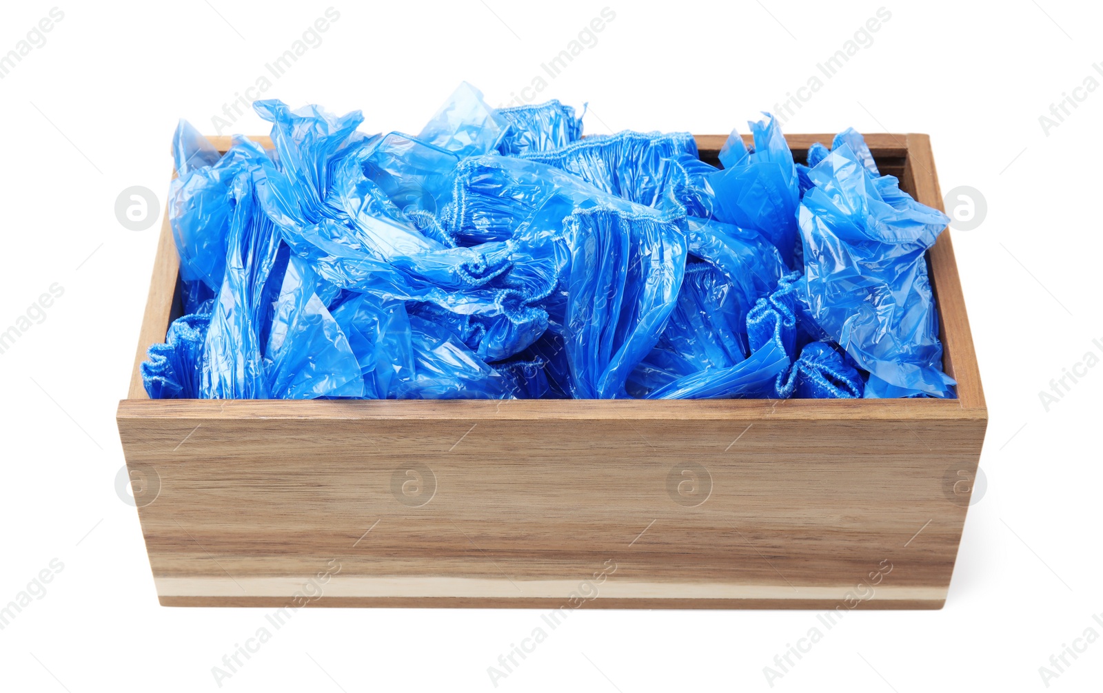 Photo of Blue medical shoe covers in wooden crate isolated on white