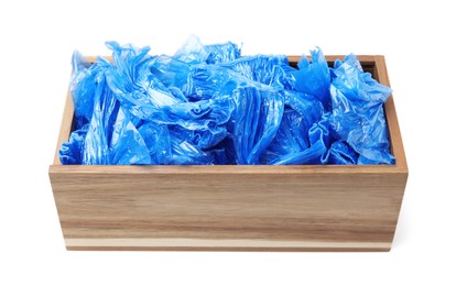 Photo of Blue medical shoe covers in wooden crate isolated on white