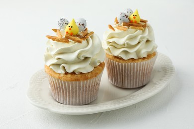 Tasty Easter cupcakes with vanilla cream on white table