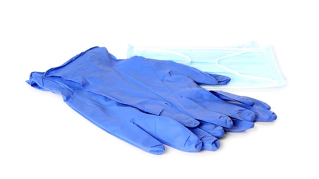 Photo of Medical gloves and protective face mask on white background