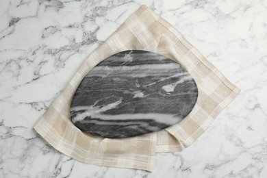 Kitchen towel and stone board on white marble table, top view