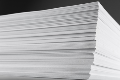 Photo of Stack of blank white paper on grey background, closeup