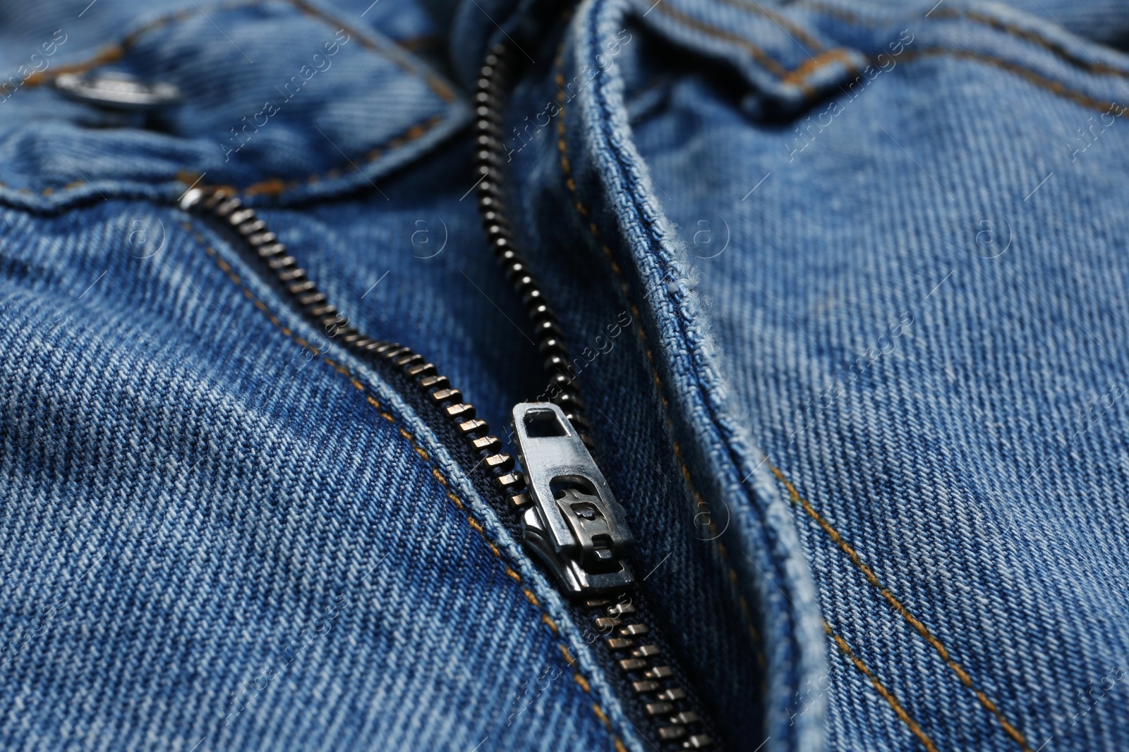 Photo of Closeup view of blue jeans with zipper as background