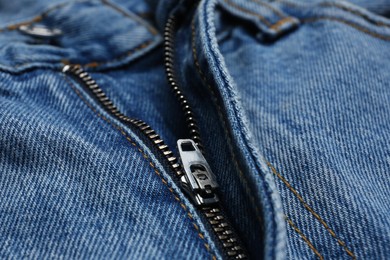 Photo of Closeup view of blue jeans with zipper as background