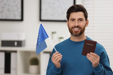 Photo of Immigration. Happy man with passport and flag of European Union indoors