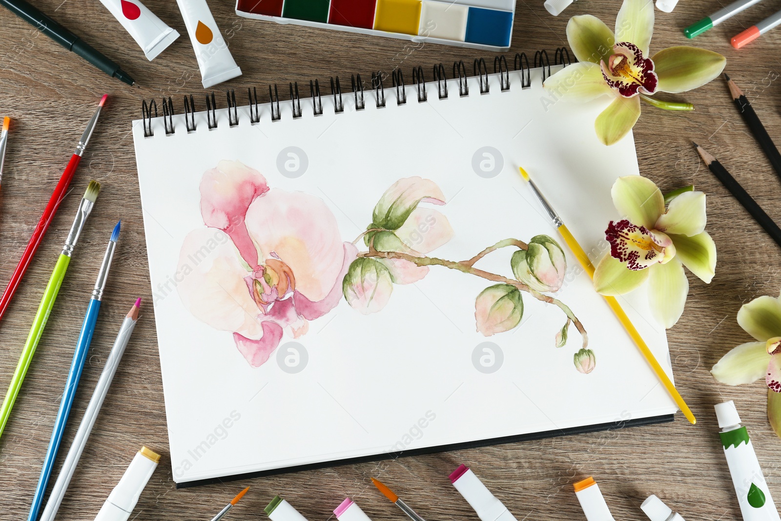 Photo of Flat lay composition with beautiful drawing of orchid
flowers on wooden table