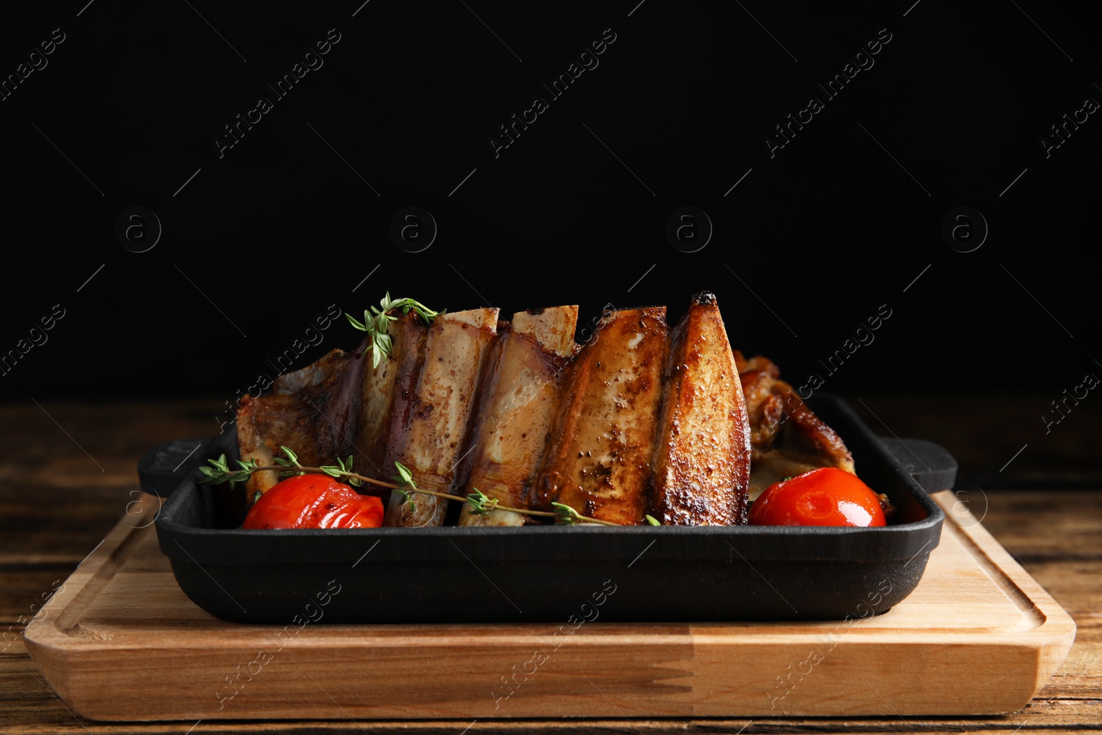 Photo of Delicious roasted ribs served on wooden table