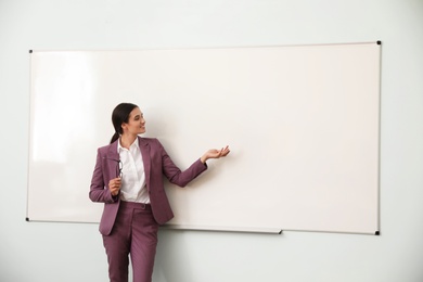 Female teacher near whiteboard in modern classroom