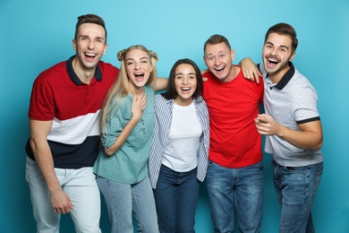 Photo of Group of friends laughing together against color background
