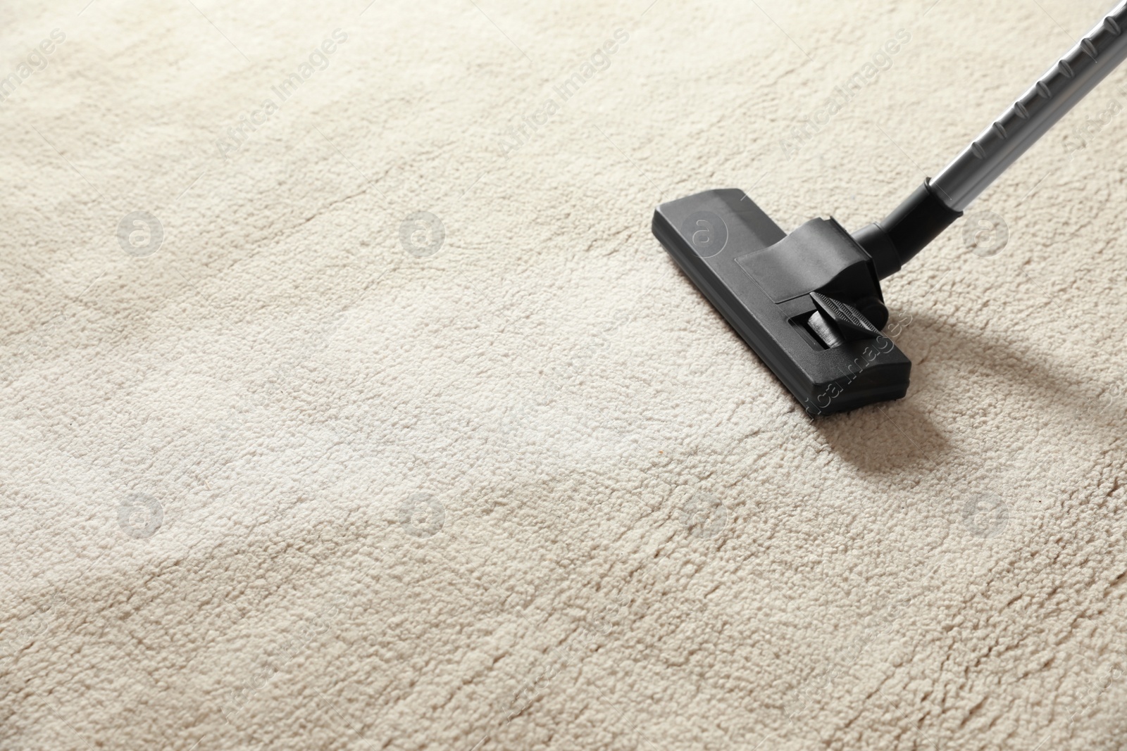 Photo of Removing dirt from light carpet with vacuum cleaner. Space for text