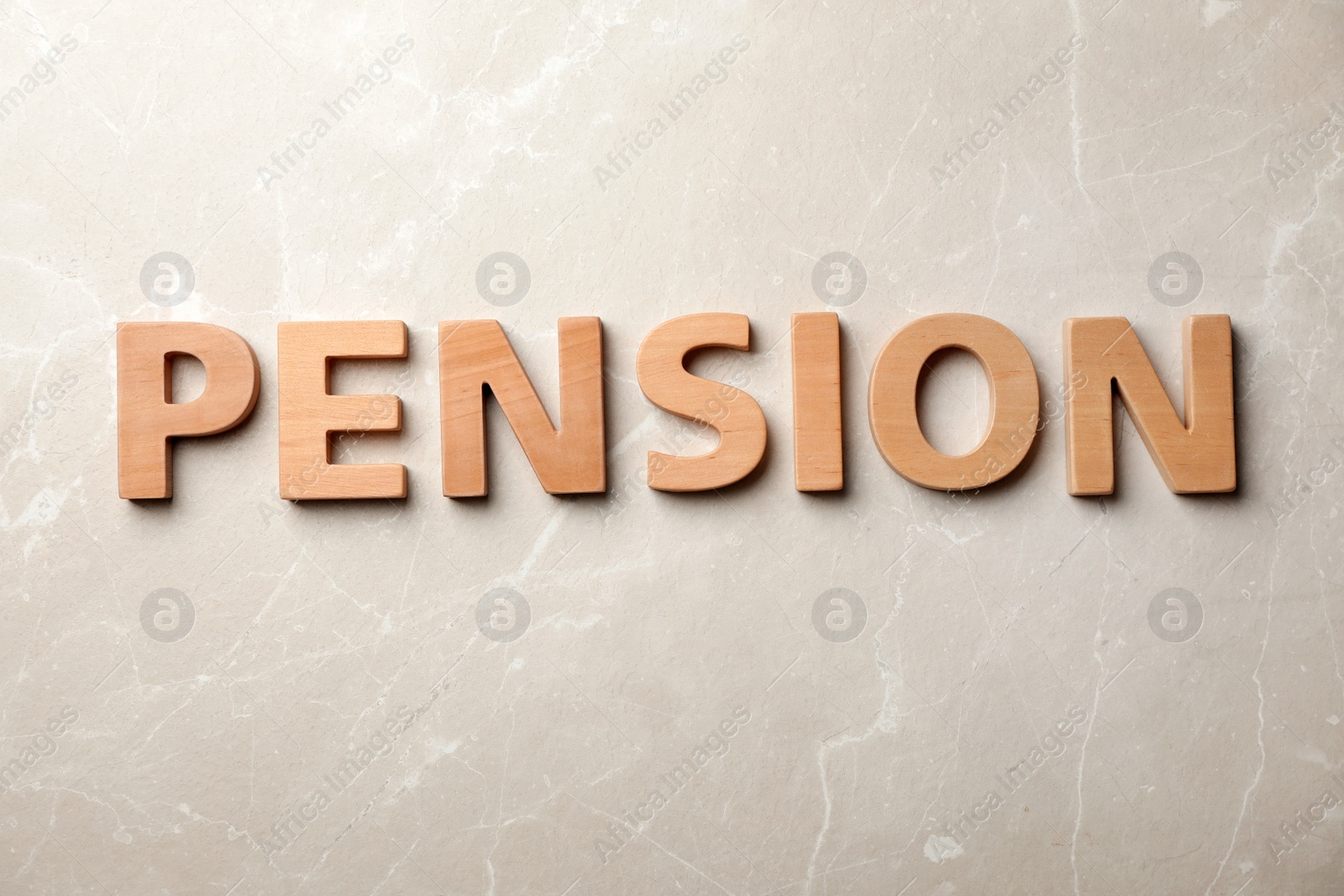 Photo of Word "PENSION" made of wooden letters on gray background