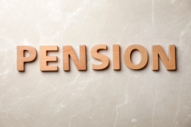 Photo of Word "PENSION" made of wooden letters on gray background