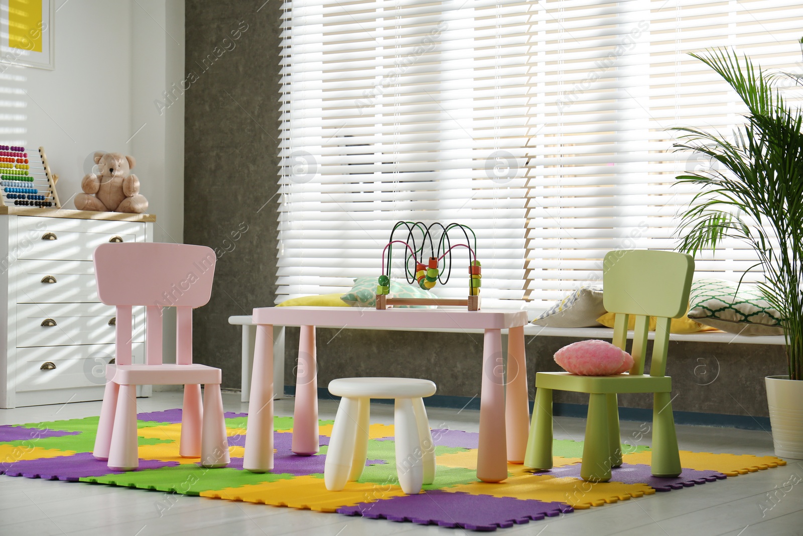 Photo of Stylish playroom interior with toys and modern furniture