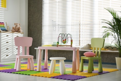 Stylish playroom interior with toys and modern furniture