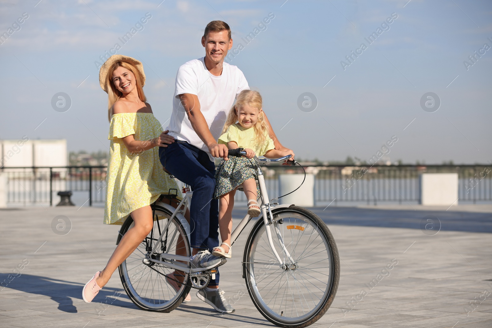 Photo of Happy family riding bicycle outdoors on sunny day