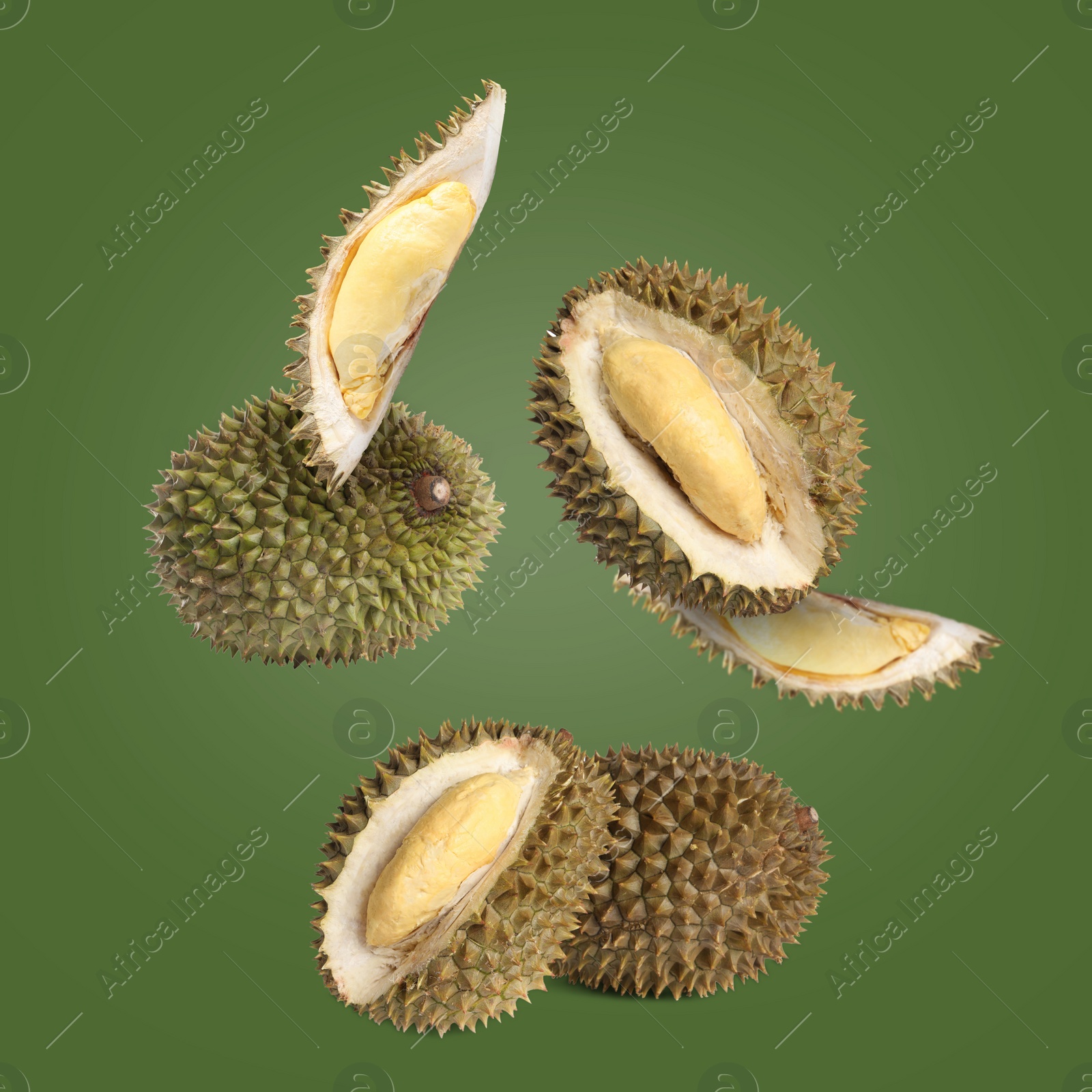 Image of Fresh ripe durians falling on green background