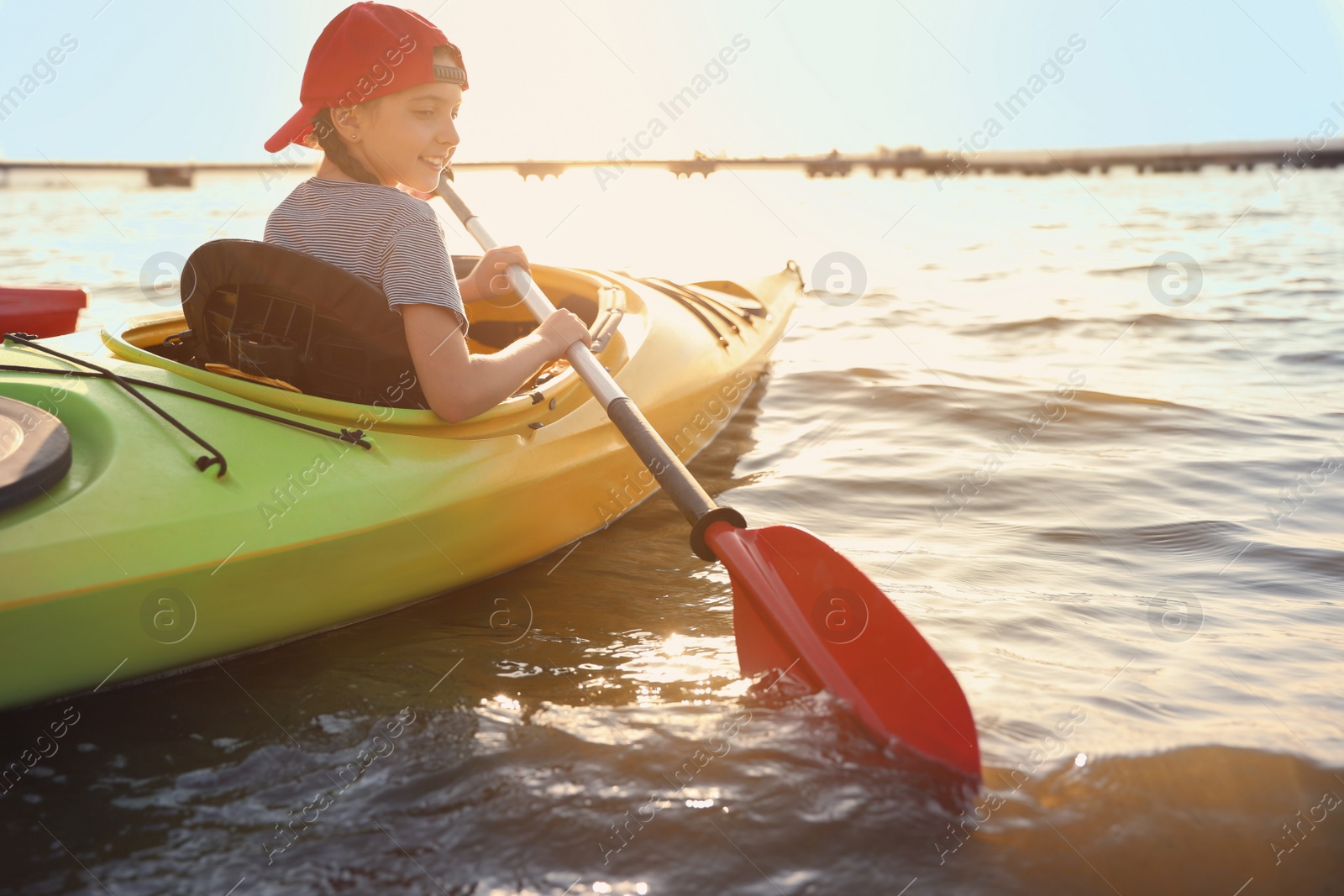 Photo of Happy little girl kayaking on river. Summer camp activity