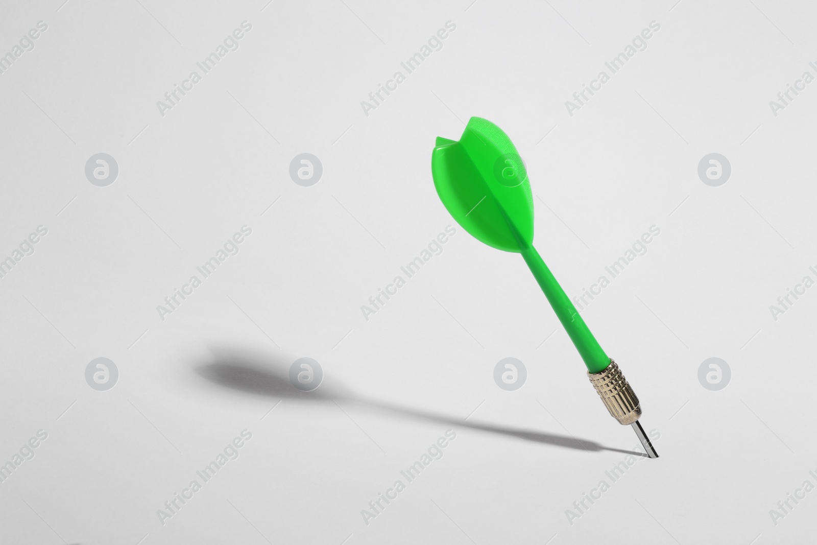 Photo of Green dart arrow for game on white background