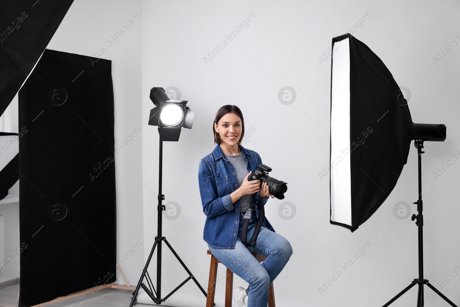 Photo of Professional photographer with camera in modern photo studio