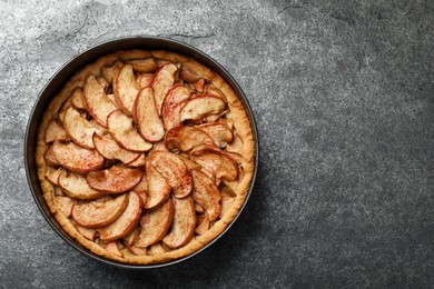 Photo of Delicious apple pie on grey table, top view. Space for text